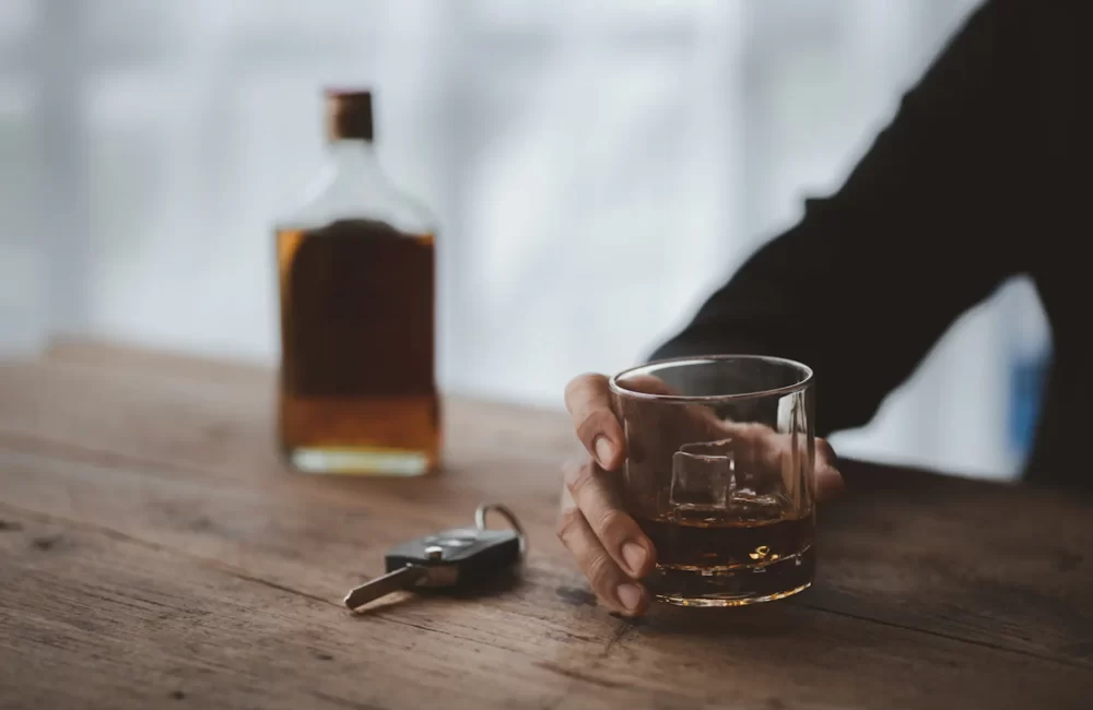 Man holding a glass of brandy, he is drinking brandy in a bar.